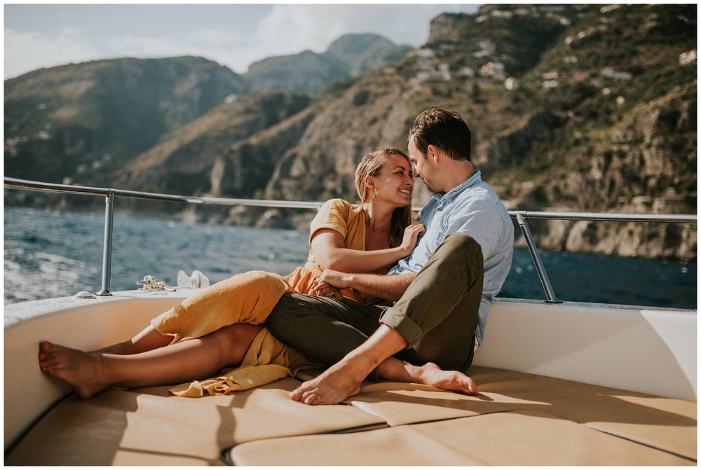 man and woman on a boat in lake with mountains